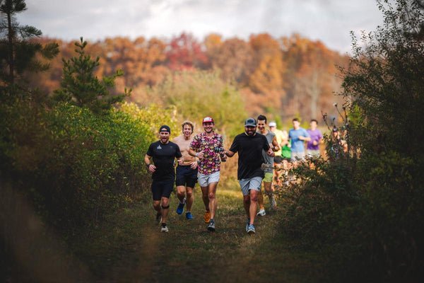 Group of trail runners charging through fall foliage at Barn Creek Backyard Ultra — a Southeast ultramarathon event featured in Friction Prescription's 2026 race partner guide