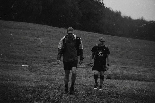 Athlete rucking with a heavy pack on a trail
