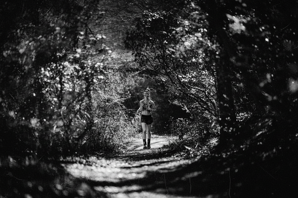 Trail runner moving through a wooded path during an endurance race